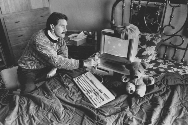 مكافي أثناء الترويج لعمله في 1989 بينما يضع سماعة الطبيب في أذنيه لفحص جهاز كومبيوتر وضع فوقه كيس ثلج.