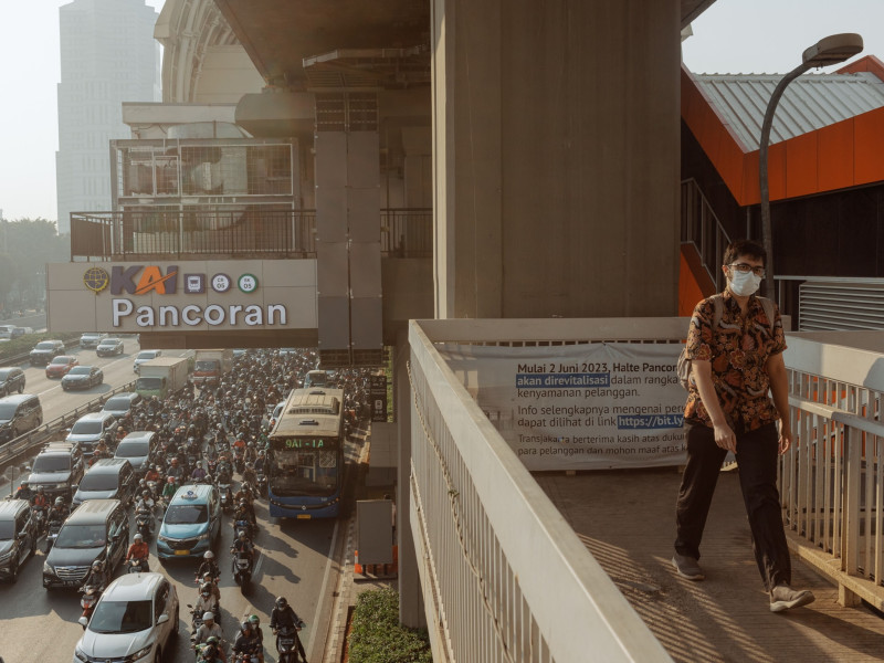 رجل يسير على طول جسر علوي في جاكرتا، إندونيسيا