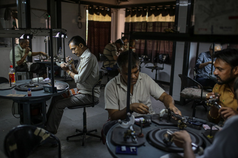 موظفون يقومون بفحص وتلميع الألماس خلال ورشة عمل في سورات، غوجارات، الهند