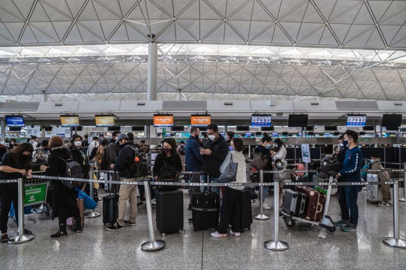 مسافرون أمام مكاتب تسجيل الوصول في مطار هونغ كونغ الدولي.