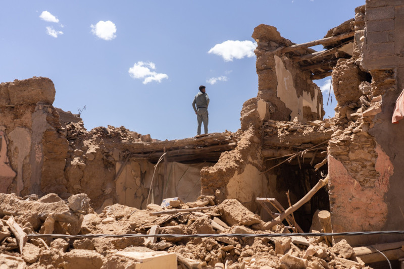مواطن يقف فوق أنقاض مبانٍ مدمرة بمنطقة الحوز إثر الزلزال الذي ضرب المغرب