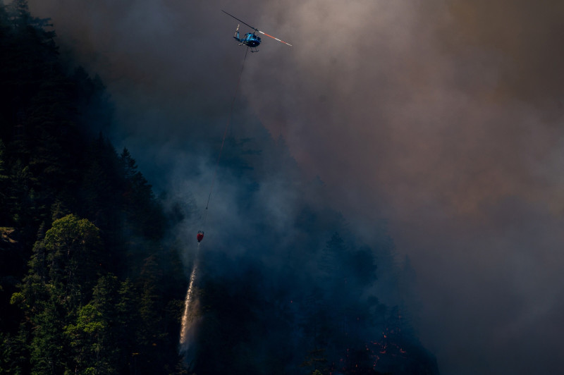 مروحية لمكافحة الحرائق تسقط الماء على حريق غابات "كاميرون بلافز" بالقرب من بورت ألبيرني، كندا