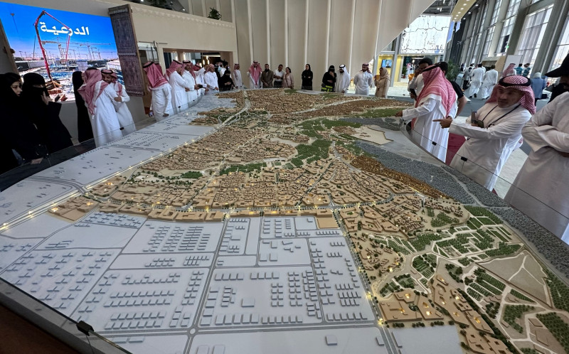 زوار في معرض "سيتي سكيب غلوبال" أمام مجسم مشروع "مدينة الدرعية" التاريخية التي يجري تطويرها في الرياض باستثمارات تصل إلى 17 مليار دولار