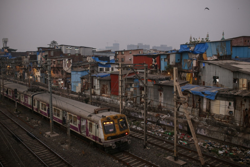 قطار يسير في حي دارافي الفقير، مومباي، الهند