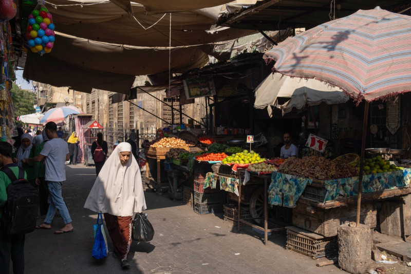 متسوقون يسيرون في سوق المغربلين للأغذية في منطقة الدرب الأحمر، القاهرة، مصر