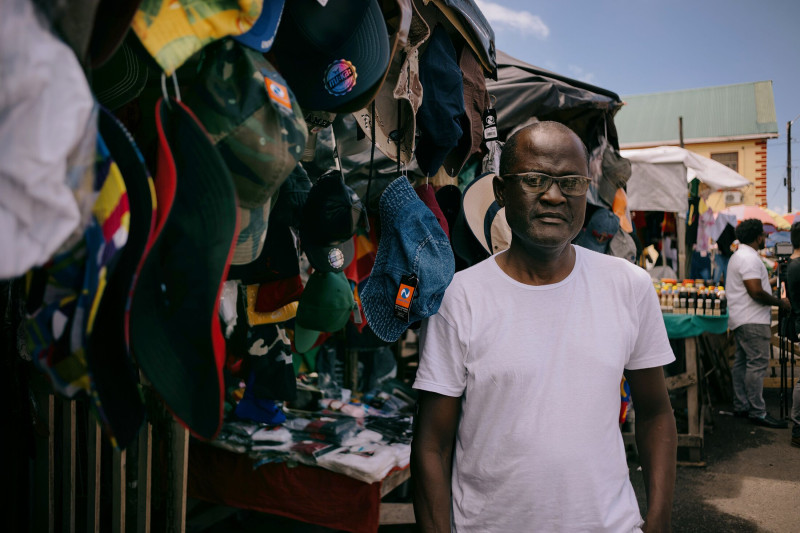 كوروين رايت أمام متجره لبيع قبعات الدلو والبيسبول، غيانا 