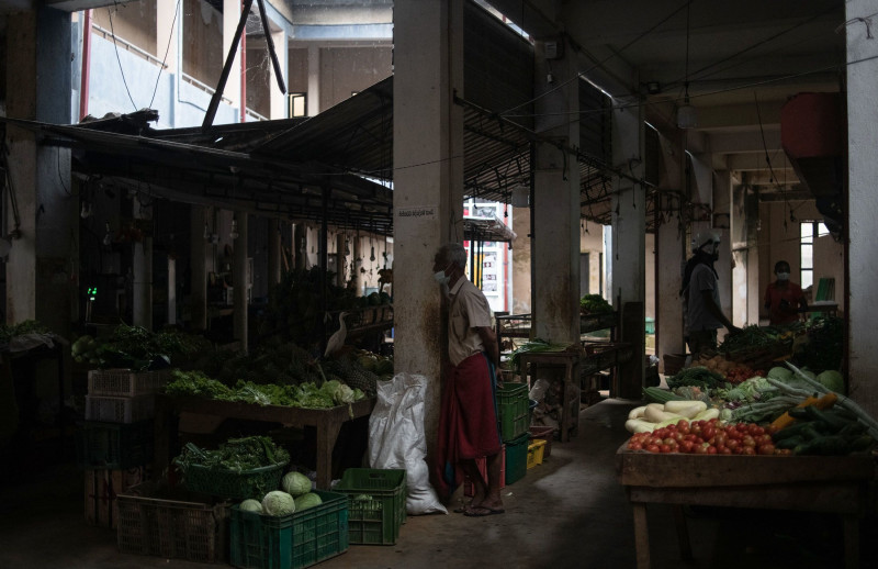 بائع فواكه وخضروات ينتظر العملاء أثناء انقطاع التيار الكهربائي اليومي في أحد أسواق هيكادوا بسريلانكا