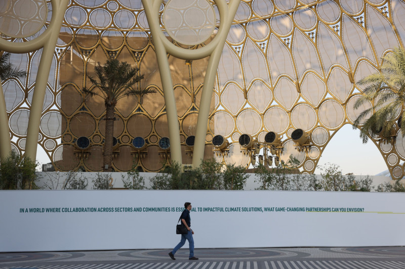  أحد الحضور يسير في ساحة في مدينة إكسبو في دبي قبل مؤتمر المناخ (كوب28)