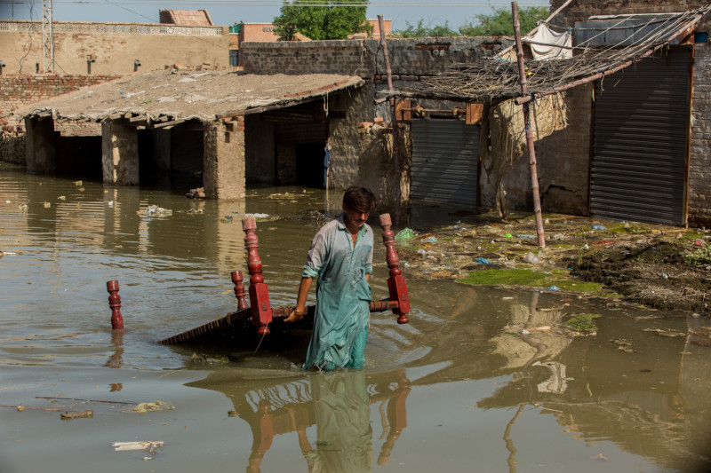 رجل يسحب طاولة عبر مياه الفيضانات في باكستان