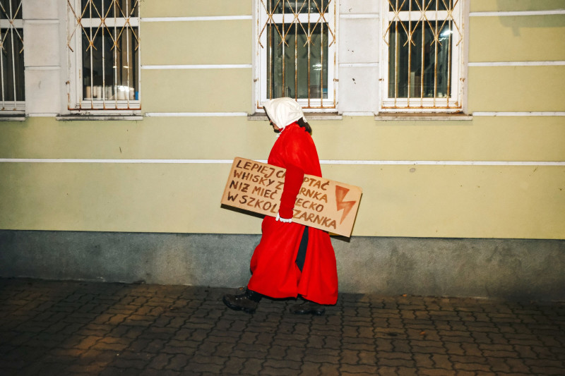 متظاهرة ترتدي رداء شخصية من رواية "حكاية الجارية" تغادر مظاهرة ضد قانون الإجهاض في بولندا خارج منزل رئيس ياروسلاف كاتشزينسكي، قائد حزب القانون والعدالة، في وارسو في نوفمبر 2022