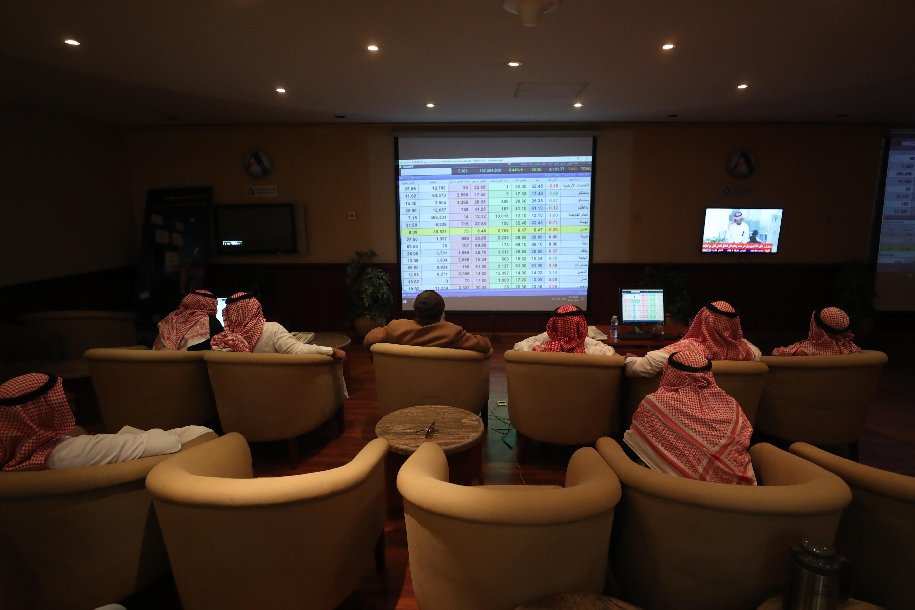 متداولون يتابعون أسعار الأسهم في السوق السعودية