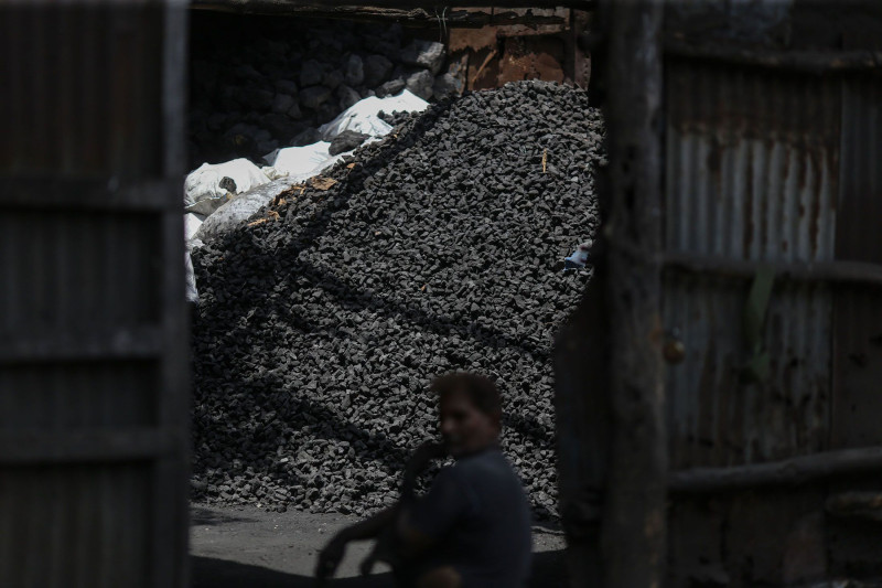 عامل يأخذ قسطاً من الراحة في سوق لبيع الفحم بالجملة في مومباي في 5 مايو