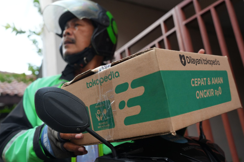 سائق تابع لشركة "جوجيك" الإندونيسية لخدمات النقل الذكي يقوم بتوصيل طلب من شركة "توكوبيديا" في جاكرتا، إندونيسيا
