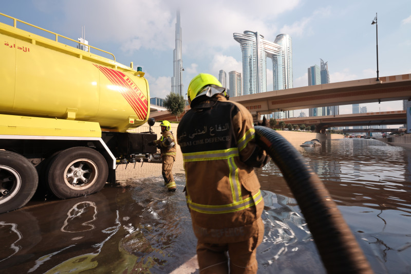 الدفاع المدني في دبي يستخدم عربة لإزالة المياه من طريق سريع غمرته المياه 