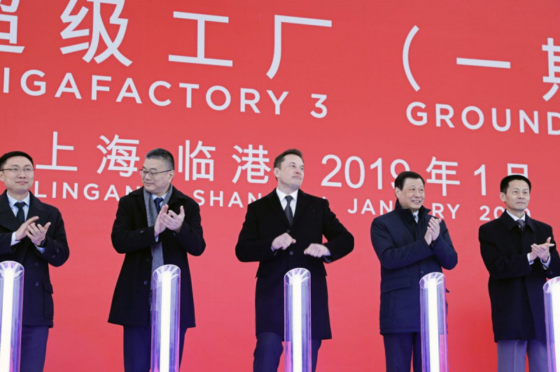 ماسك، في 2019، مع يينغ يونغ، عمدة شنغهاي في ذلك التوقيت، الشخص الثاني من جهة اليمين، ووو تشينغ، نائب عمدة شنغهاي، إلى اليمين، أثناء فعالية بموقع مصنع "تسلا"