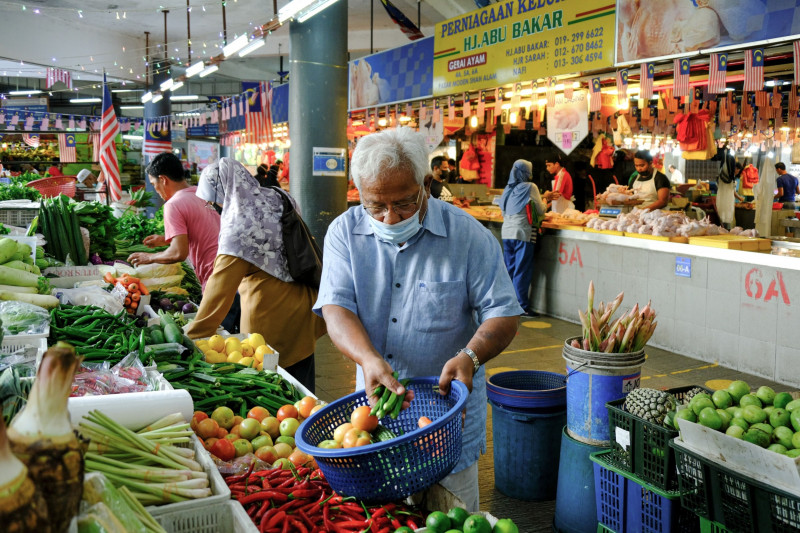مواطنون يشترون الخضراوات من السوق في شاه علم، ماليزيا