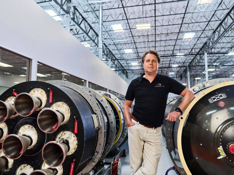 بيتر بيك في مقرّ شركة "روكيت لاب" إلى جانب صواريخ "الكترون" من إنتاج الشركة.