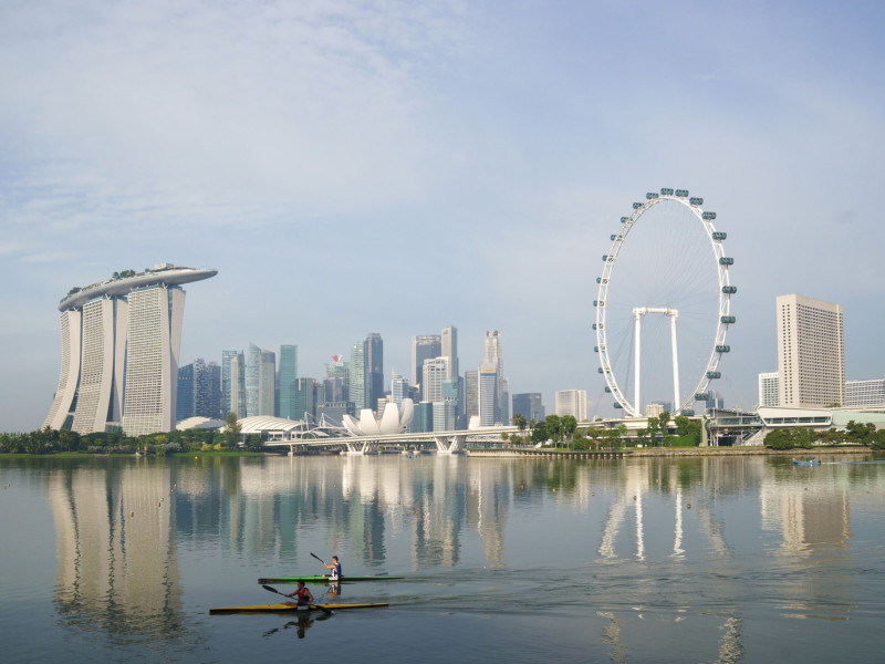 لاعبو رياضة التجديف يجدفون عبر المنطقة التجارية المركزية، في خليج مارينا في سنغافورة، يوم الأحد 3 أكتوبر 2021