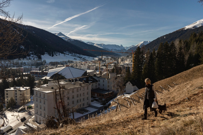 إمرأة تمشي مع كلبها على أحد المنحدرات في دافوس، سويسرا، يوم 6 يناير 2023