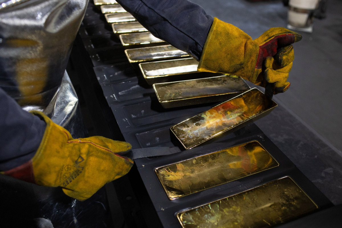 عامل يرفع سبائك الذهب المبردة زنة 12 كيلوغراماً من قوالبها بمصنع بريوكسكي للمعادن غير الحديدية في كاسيموف ، روسيا 