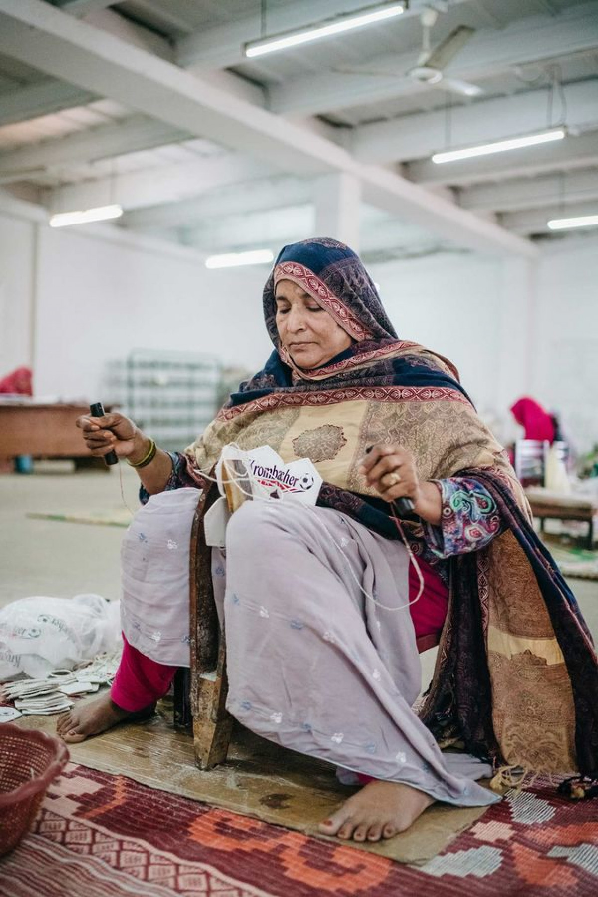 سيدة تخيط أطراف قطع لإنتاج كرة قدم داخل مصنع في بلدة سيالكوت الباكستانية التي تعتبر بمثابة عاصمة صناعة كرات القدم في العالم