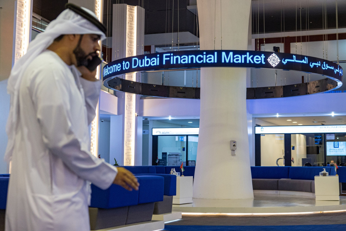 مستثمر يتحدث على هاتف محمول خلال زيارة إلى سوق دبي المالي، دبي، الإمارات.